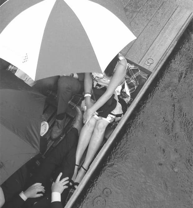 Guests enjoying a punt tour under an umbrella