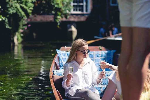 Guests enjoying champagne on a punt on the River Stour