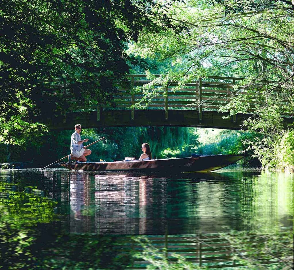 Punting on the River Stour under a wooden bridge